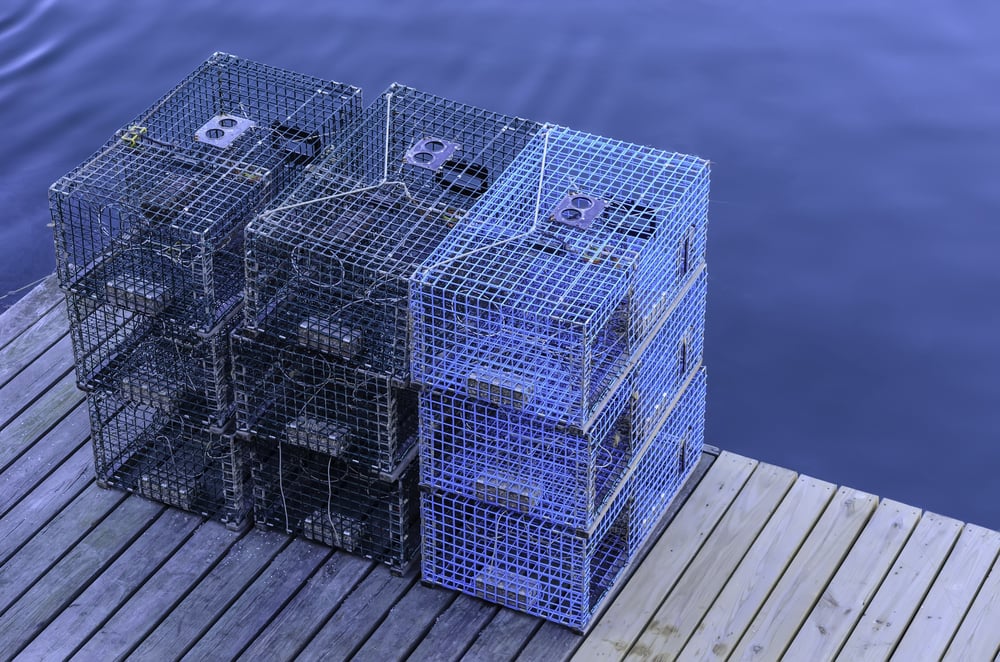 Three stacks of lobster traps on a wooden dock in Maine